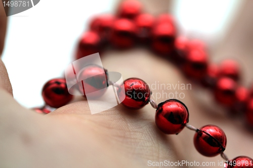 Image of hand with red pearls