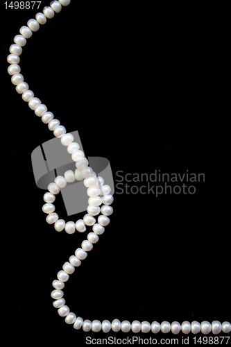 Image of White pearls on the black silk background 