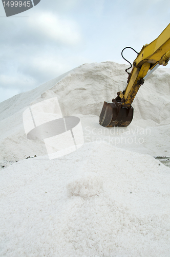 Image of Excavator digging pile salt