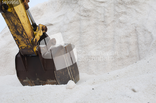 Image of Excavator digging pile salt