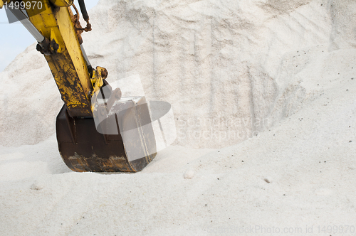 Image of Excavator digging pile salt