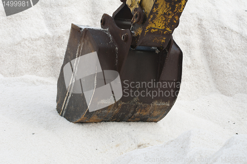 Image of Excavator digging pile salt