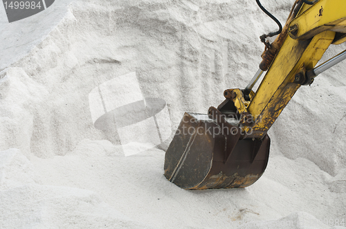 Image of Excavator digging pile salt