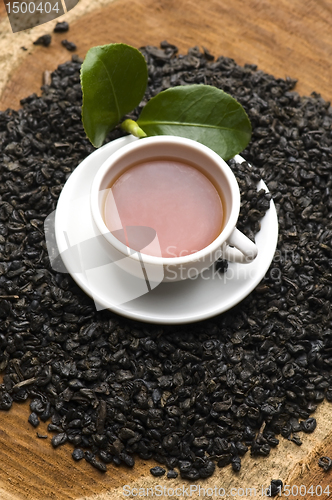 Image of A cup of green tea with freh leaves