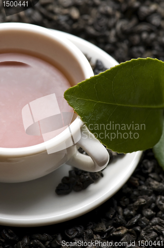 Image of A cup of green tea with freh leaves