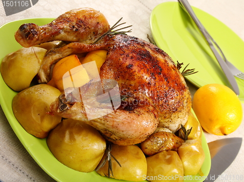 Image of Chicken stuffed with lemons, apples and rosemary.