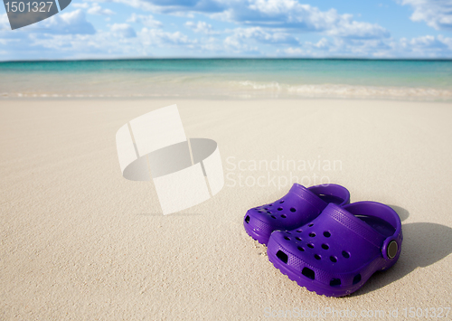 Image of Small kids boots on the beach sand