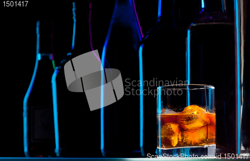 Image of Row of bottles and drink with ice