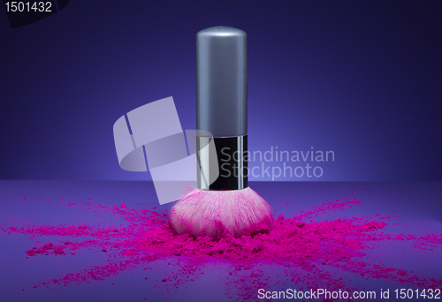 Image of makeup brush and face powder scattered