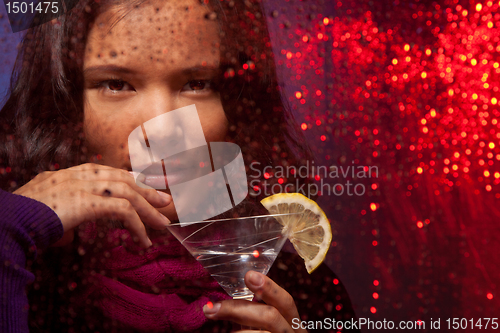 Image of Attractive Asian woman with drink in cold rainy weather