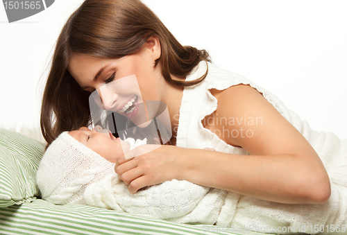 Image of Mother playing with baby in the bed
