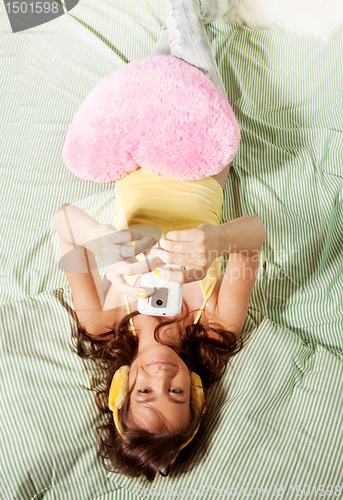 Image of Happy teenage girl photographing with with phone