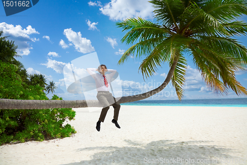 Image of Happy businessman sitting on the palm and relax