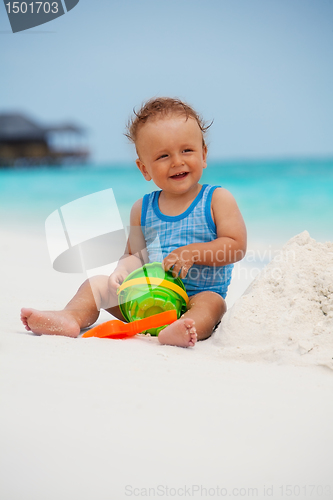 Image of Kid playing with sand on the beach