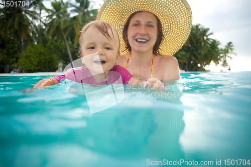 Image of Kid swimming with mothers help