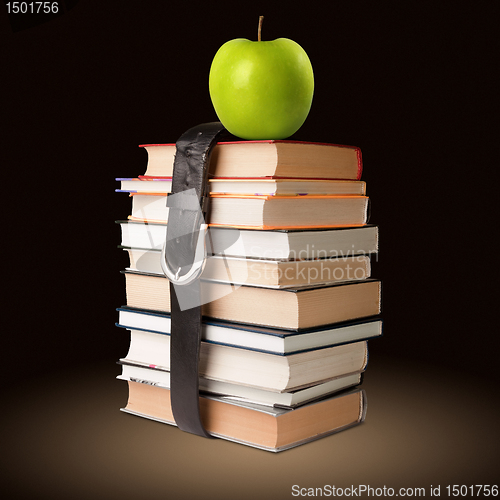 Image of books pile with belt and apple