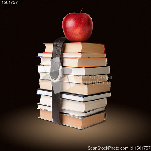 Image of books pile with belt and apple