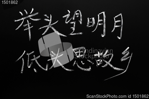 Image of Chinese characters of a famous ancient poem means "Lifting myself to look, I found that it was moonlight.Sinking back again, I thought suddenly of home"