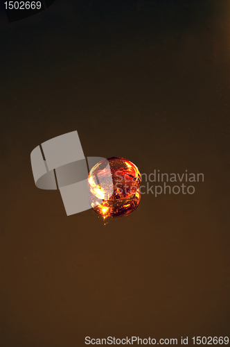 Image of Glass pebble on a dark mirror background.