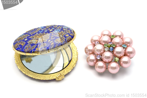 Image of  cosmetic mirror and brooch