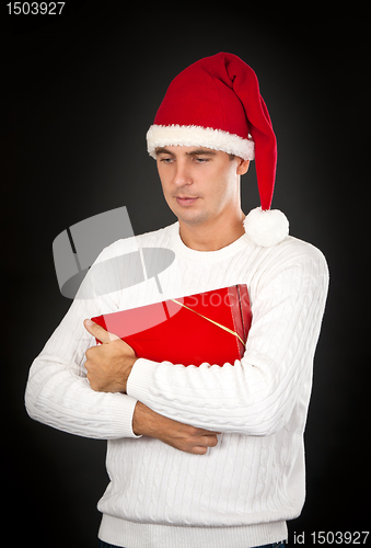 Image of sad man in a hat Santa with a gift