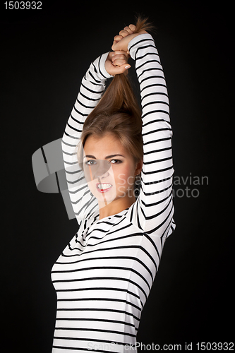 Image of Beautiful girl in a striped dress pulls his hair