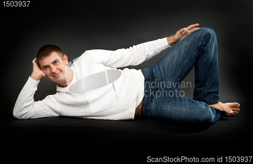 Image of man in a white sweater lying