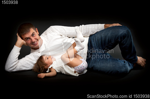 Image of happy father with his little daughter lying