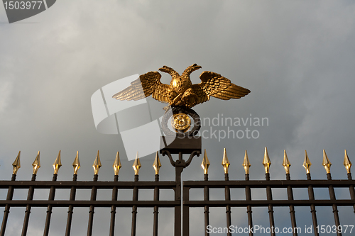 Image of gold double eagle on a steel fence