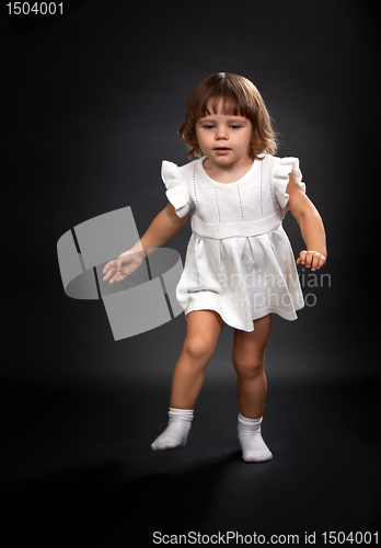 Image of the first steps of a little girl on a black background.