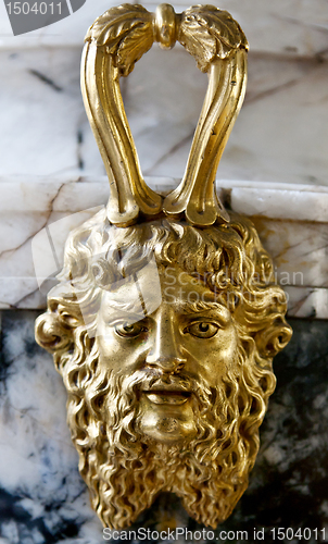 Image of decorative gold face on a marble bowl in the museum.