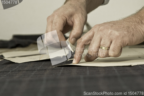 Image of detail of tailor's hand with chalk