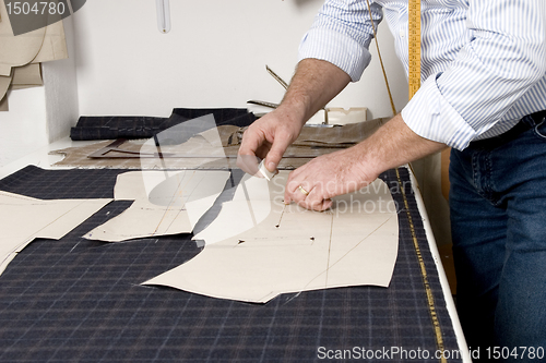 Image of detail of tailor's hand with chalk