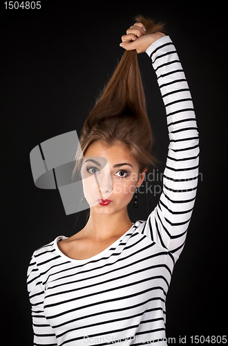 Image of Beautiful girl in a striped dress pulls his hair