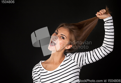 Image of Beautiful girl in a striped dress pulls his hair