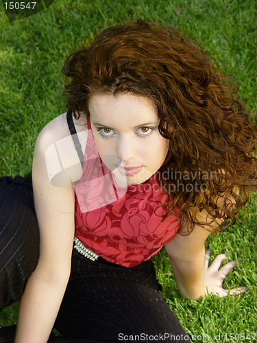 Image of Beautiful girl sitting on the grass