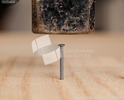 Image of Nail being hit into wood by hammer