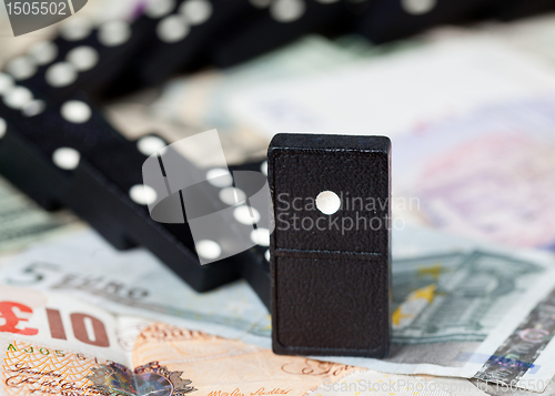 Image of Fallen dominoes on bank notes