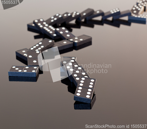 Image of Dominoes collapsed on reflective surface