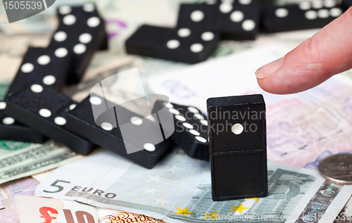 Image of Standing dominoes on bank notes