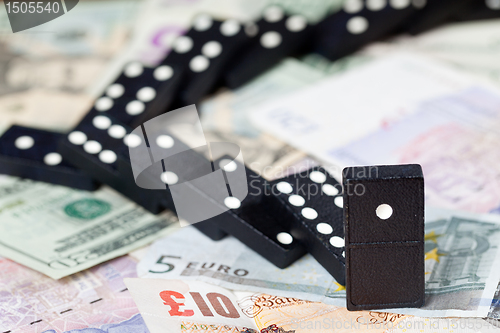 Image of Fallen dominoes on bank notes