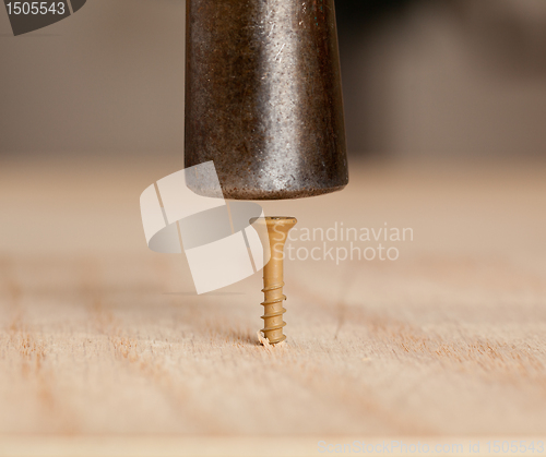 Image of Screw being hit into wood by hammer