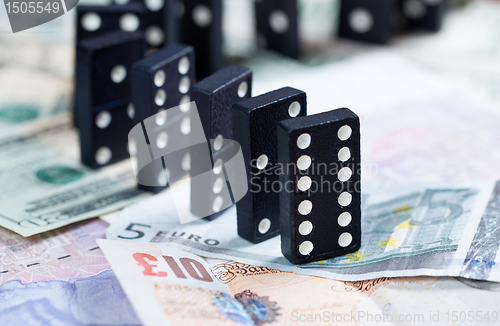 Image of Standing dominoes on bank notes