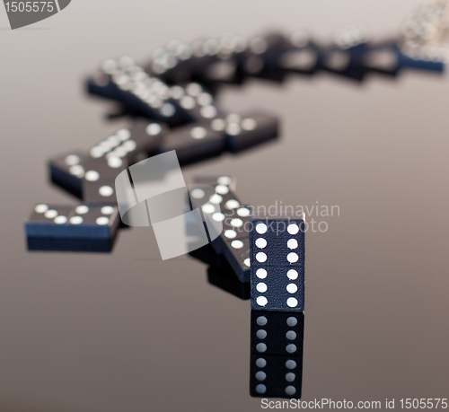 Image of Dominoes collapsed on reflective surface