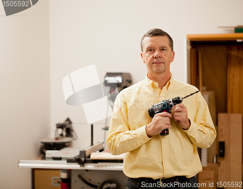Image of Senior man holding power drill