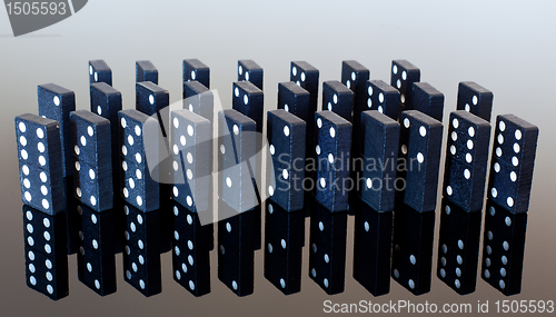 Image of Dominoes standing on reflective surface