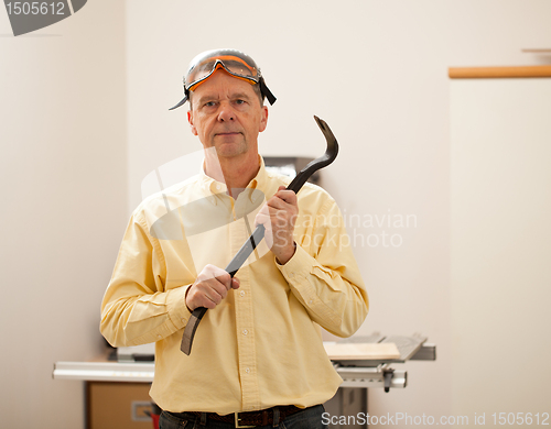 Image of Senior man holding a crowbar