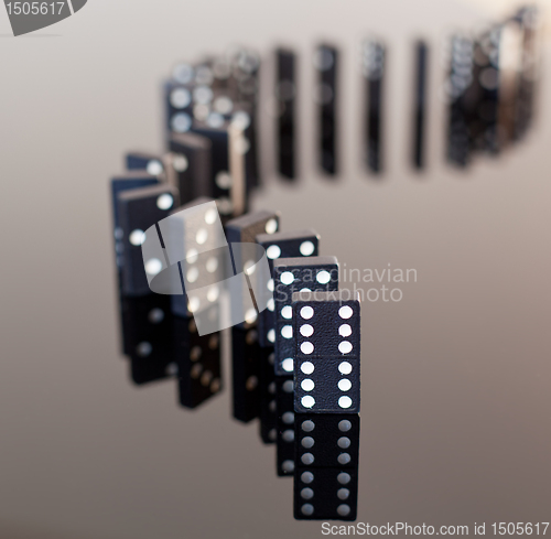 Image of Dominoes standing on reflective surface