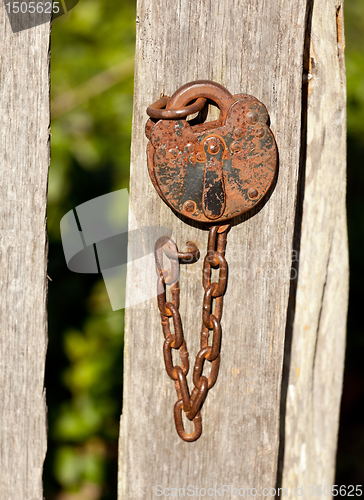 Image of Antique lock and chain on wood