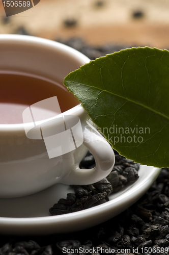 Image of A cup of green tea with freh leaves